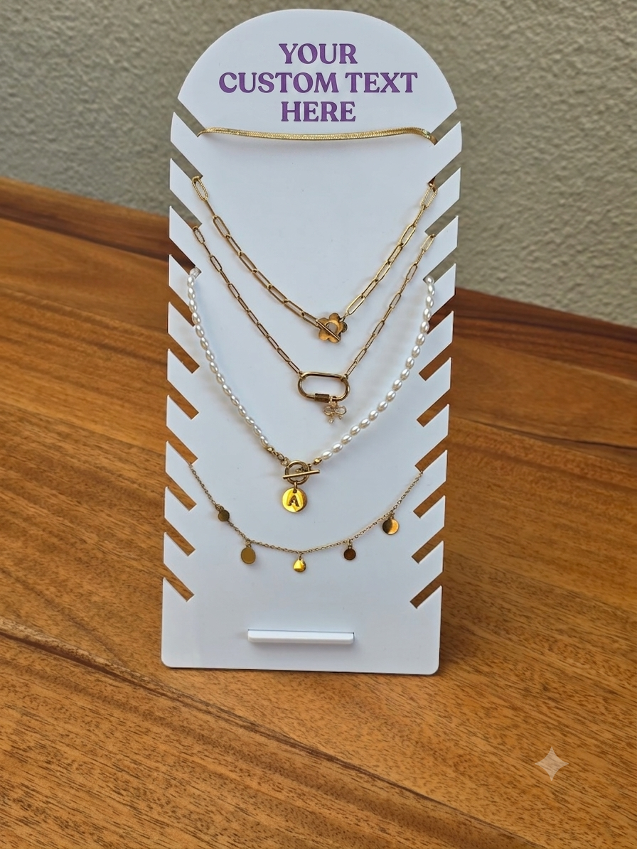 A three-layer necklace set displayed on a white card stand. The set includes a gold chain, a white pearl chain, and a delicate gold chain with small gold disc charms.